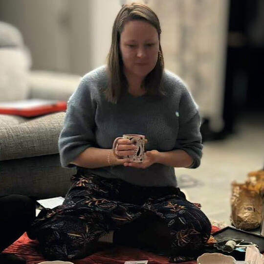 Noémie Khosravi en tailleur avec une tasse, moment de pause